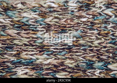Primo piano sulla texture in lana di maglia. Maglione o sciarpa con filo intrecciato melange a colori come backgro Foto Stock