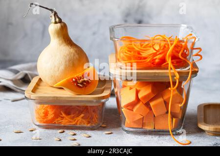 Scatole in vetro con verdure fresche d'arancia crude. Zucca grattugiata e pezzi grandi. Pasto sano P Foto Stock