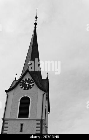 Una struttura torreggiante in cima ad una chiesa, spesso adornata con dettagli architettonici e una campana, che serve come un punto di riferimento prominente in una comunità. Foto Stock