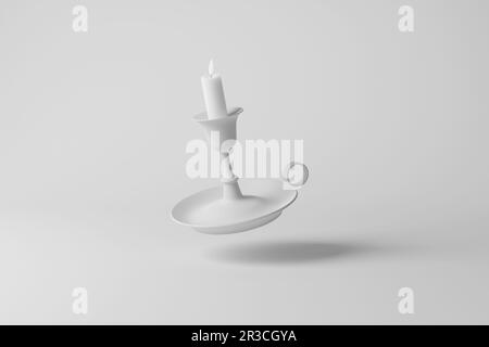 Portacandele bianco con una candela accesa che galleggia in un'ombra di fusione a mezz'aria su sfondo bianco in scala di grigi monocromatico. Illuminazione antica Foto Stock
