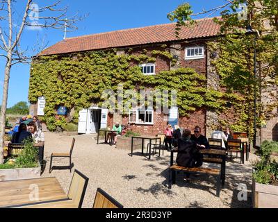 Snape Maltings, Suffolk, Regno Unito - 23 Maggio 2023: Posti a sedere all'esterno al Malt Cafe. Foto Stock