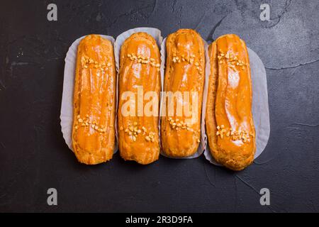 Dolci e deliziosi eclair su sfondo nero Foto Stock