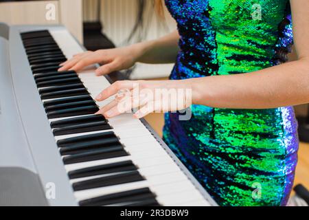 La giovane donna sta giocando in studio su un sintetizzatore Foto Stock
