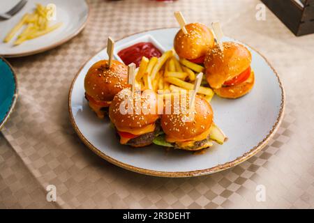 Mini hamburger e patate fritte sul piatto Foto Stock