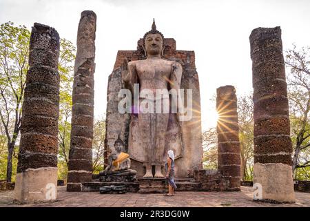 Touristin vor dem riegen stehende Buddha im Tempel Wat Saphan Hin, UNESCO Welterbe Geschichtspark Sukhothai, Thailandia, Asien | Female turista a. Foto Stock