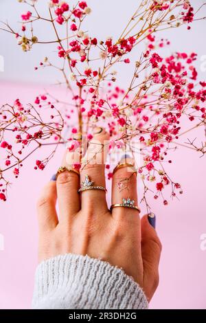 Respiro del bambino. Suggerimento. Mano di donna con anelli di gioielleria. Concetto di gioielleria e lusso. Bella donna con accessori eleganti Foto Stock