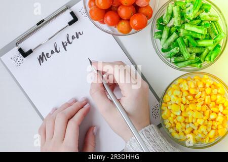 Pasto piano. Tre ciotole di verdure surgelate cibo di mais giallo, fagioli verdi, pomodori rossi. Colori del semaforo. Vendemmia Foo Foto Stock