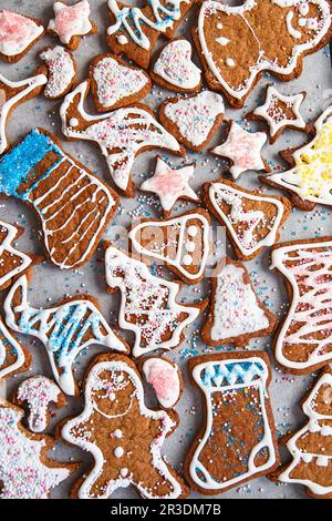 Biscotti di pan di zenzero fatti in casa a Natale. Biscotti fatti in casa con pan di zenzero, decorati in clazed per natale. Vista dall'alto dei cookie nella scheda Foto Stock