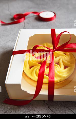 Deliziosa crostata gialla nella confezione regalo. Dessert gustoso e colorato - crostata al limone preparata dallo chef Foto Stock