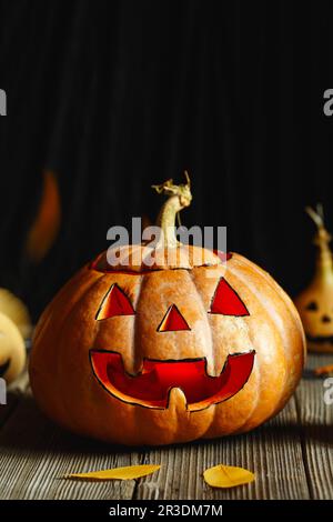 Design di Halloween con zucche. Orribile simbolo di Halloween - Jack-o-lanterna. Testa spaventosa di zucca con fiamma e qualche piccolo Foto Stock