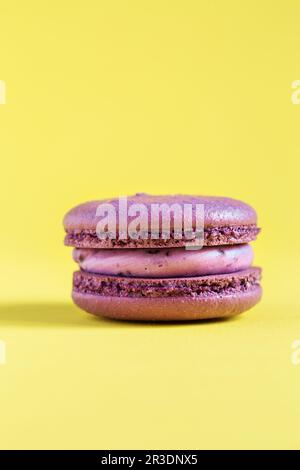Macaron torta viola o macaroon su sfondo giallo. Foto Stock