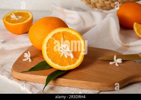 Tavola di arance con foglie su sfondo bianco Foto Stock