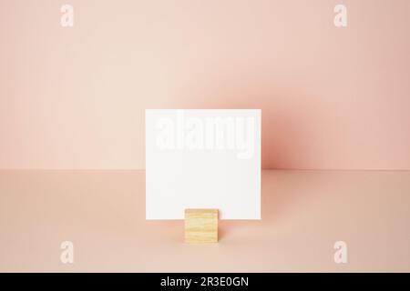 Blocco per appunti bianco con supporto in legno su scrivania rosa. sfondo parete rosa. spazio di copia Foto Stock
