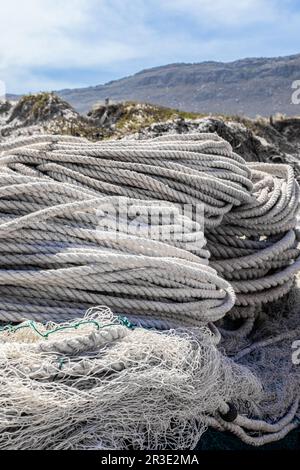 Rete da pesca tradizionale e corda su una piccola barca a remi Foto Stock