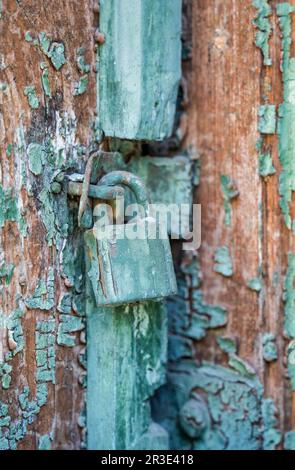 Vecchio lucchetto arrugginito su una porta di legno Foto Stock