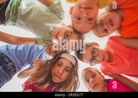 La squadra di ragazzi e ragazze si accatastano le mani Foto Stock