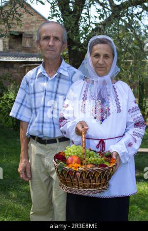 Ritratto di anziani con un cesto nel cortile, nonni ucraini Foto Stock