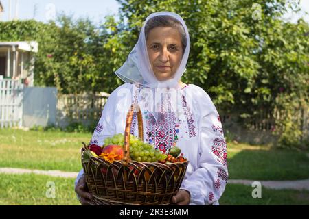 nonna in una camicia festosa ricamata con frutta Foto Stock