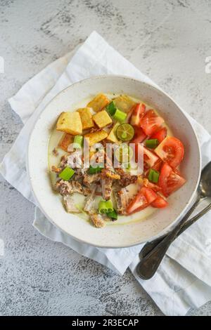 Soto Betawi è una zuppa indonesiana fatta di latte di cocco e riempita di manzo, patate e pomodori Foto Stock