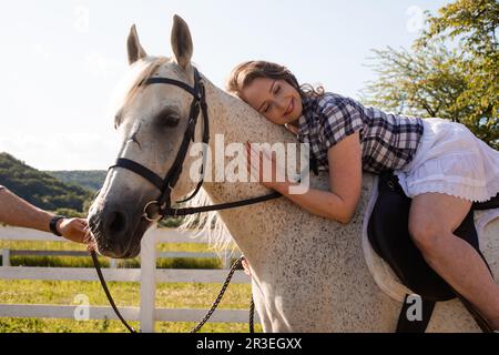 La giovane donna trascorre del tempo con il suo cavallo preferito Foto Stock