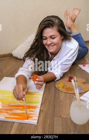 Pittore creativo in lavorazione. Artista luogo di lavoro, hobby, attrezzi artigianali. Artista femmina pittura tela. Giovane professionista wom Foto Stock