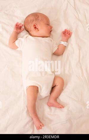 Il neonato dorme sul letto dell'ospedale di maternità Foto Stock