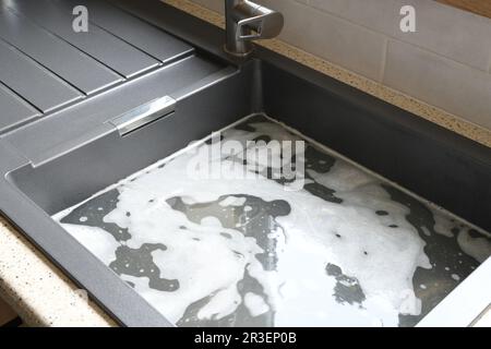 Traboccante lavello da cucina, scarico intasato, problemi di impianto idraulico, cercando di sostruire Foto Stock