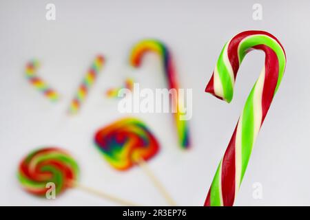 Lecca lecca colorata, caramella dolce brillante nei colori bianco, rosso e verde. Lollipop di Natale o Capodanno su sfondo bianco con altri lolli multicolore Foto Stock