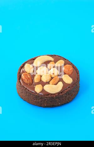 Tartelletta di cioccolato alla noce su sfondo blu Foto Stock