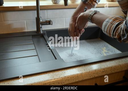 Traboccante lavello da cucina, scarico intasato, problemi di impianto idraulico, cercando di sostruire Foto Stock