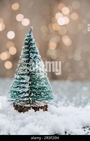 Albero di Natale su sfondo bokeh chiaro. Disegno minimalista color pastello per il nuovo anno. Biglietto di auguri per le vacanze invernali. Foto Stock