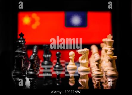 Immagine concettuale della guerra tra Cina e Taiwan utilizzando pezzi di scacchi e bandiere nazionali Foto Stock