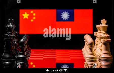 Immagine concettuale della guerra tra Cina e Taiwan utilizzando pezzi di scacchi e bandiere nazionali Foto Stock