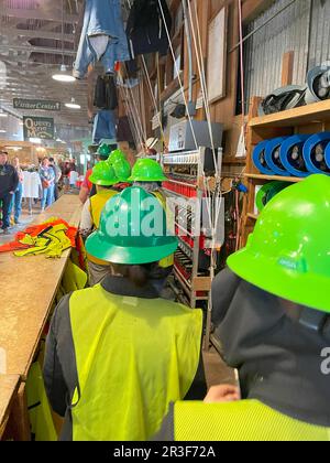 Le persone che raccolgono i loro indumenti di sicurezza prima di scendere nella miniera Copper Queen Mine a Bisbee, Arizona Foto Stock