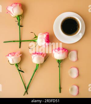 Parola AMORE fatto di fiori rosa rosa tenue rose e caffè tazza su sfondo beige. Concetto di amore. Giacitura piatta. Composizione minima. ROM Foto Stock