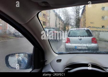 Vista dall'auto attraverso un vetro bagnato dalla pioggia con una visione poco chiara del traffico, Witten, Germania Foto Stock