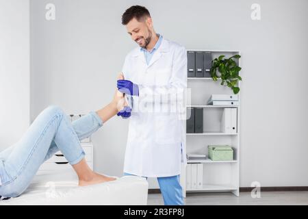 Soletta ortopedica maschile che si adatta al piede del paziente in ospedale Foto Stock