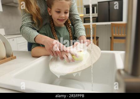 Piatto di lavaggio madre e figlia sopra lavello interno, primo piano Foto Stock