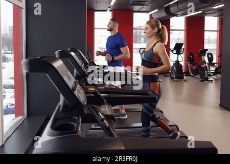 Bella coppia di allenamento su tapis roulant in palestra Foto Stock