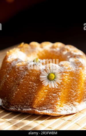 Cupcake decorato fiore camomilla in stile rustico. Foto autentica. Sfondo del biglietto d'auguri di Pasqua. Sole raggi Homem Foto Stock