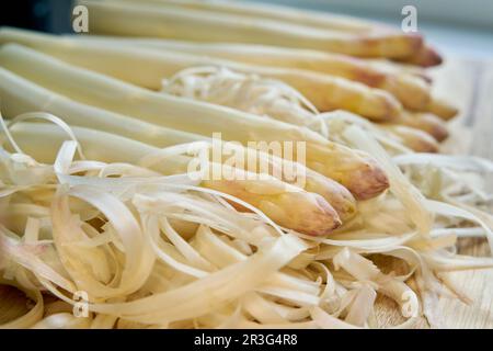 Asparagi bianchi sbucciati freschi direttamente dal campo su un tavolo da cucina Foto Stock