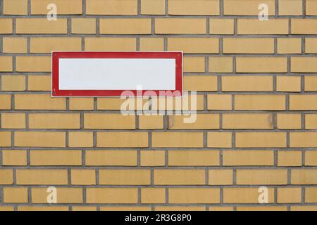 Cartello bianco vuoto con spazio libero sul muro di mattoni Foto Stock