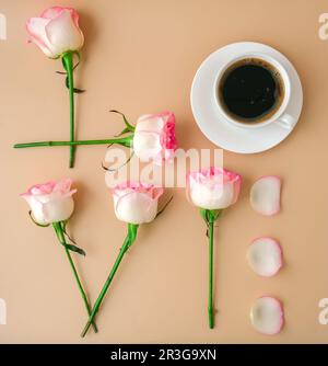 Parola AMORE fatto di fiori rosa rosa tenue rose e caffè tazza su sfondo beige. Concetto di amore. Giacitura piatta. Composizione minima. ROM Foto Stock