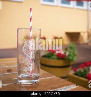 Bicchiere Coca-Cola vuoto con paglia sul tavolo nel ristorante Foto Stock