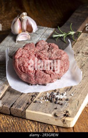 Carne macinata cruda su legno scuro Foto Stock