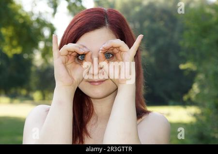 La giovane donna imita un gufo Foto Stock