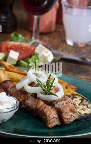 Spiedini di souvlaki greci con patatine fritte Foto Stock