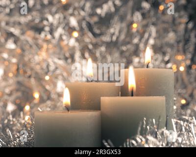 Quarta candela dell'Avvento brucia, sfondo argento con spazio libero del testo Foto Stock