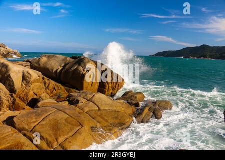 Onde che si infrangono sulle rocce Foto Stock