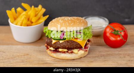 Hamburger cheeseburger menu fast food con patatine fritte su tavola panoramica di legno Foto Stock